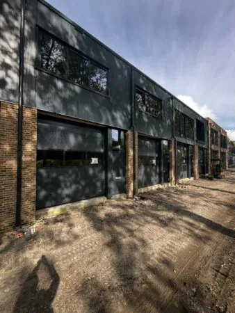 Nieuwbouw bedrijfsunits aan de Broekdijk West 10 in aanbouw, met donkere gevelbekleding en grote ramen.